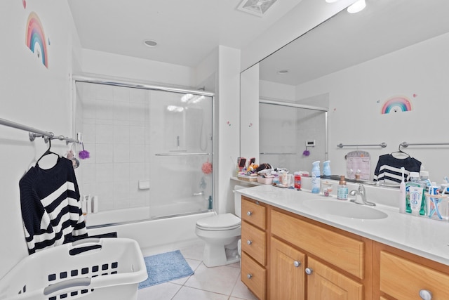 bathroom with visible vents, toilet, shower / bath combination with glass door, tile patterned flooring, and vanity