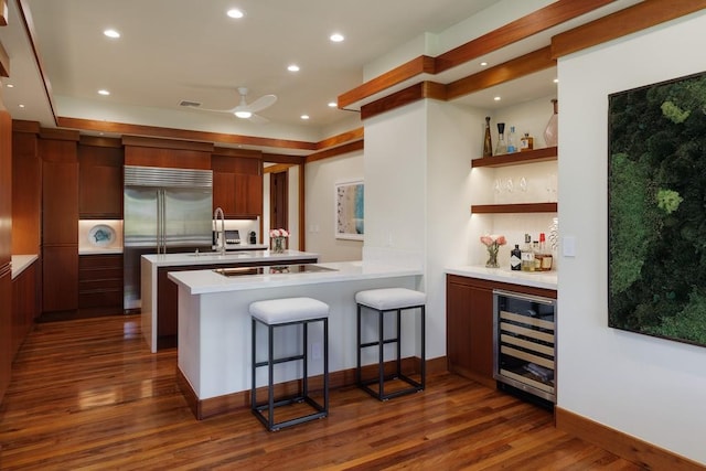 kitchen with wine cooler, light countertops, dark wood-type flooring, stainless steel built in fridge, and modern cabinets