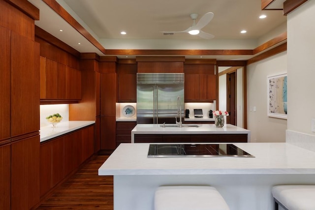 kitchen with cooktop, stainless steel built in fridge, modern cabinets, and light countertops