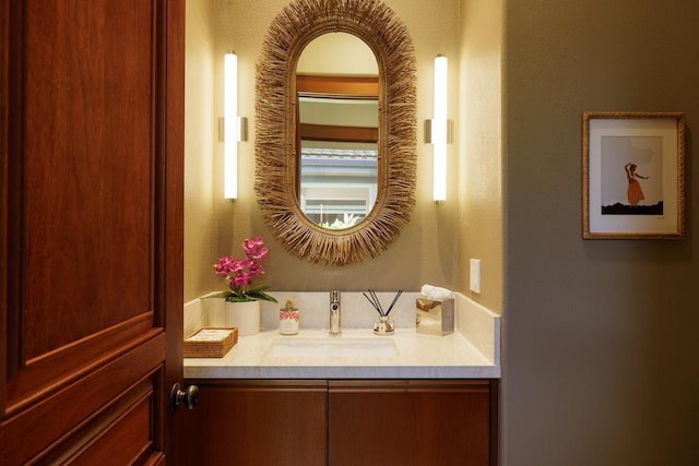 bathroom with a textured wall and vanity