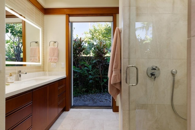 full bathroom with a stall shower, tile patterned flooring, decorative backsplash, and vanity