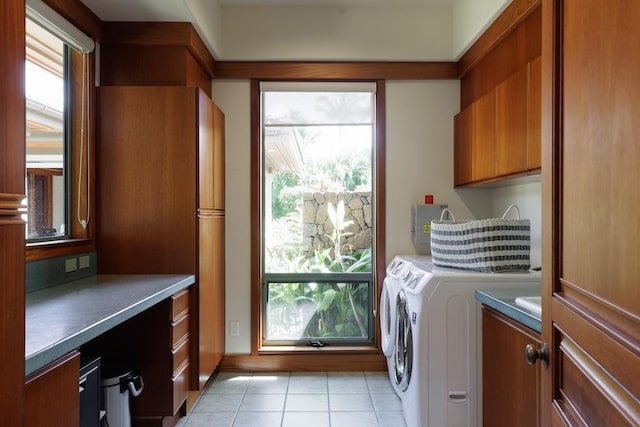 laundry room featuring washing machine and dryer, cabinet space, and a healthy amount of sunlight