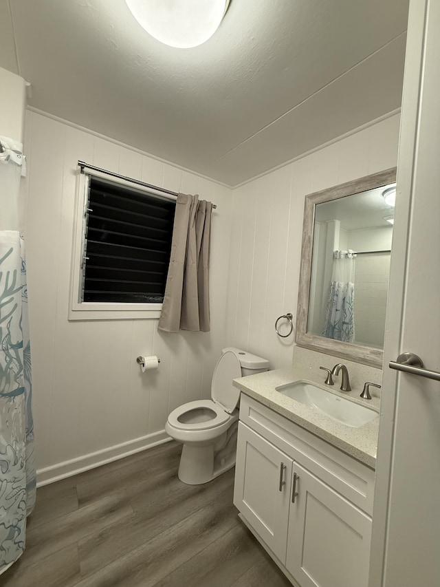 bathroom with vanity, a shower with shower curtain, toilet, and wood finished floors