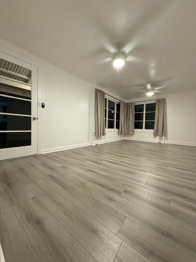 unfurnished living room featuring wood finished floors and baseboards