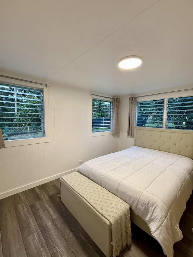 bedroom featuring baseboards and dark wood-style flooring