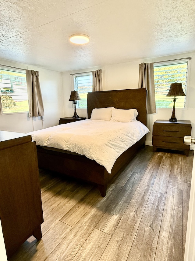 bedroom with a textured ceiling and hardwood / wood-style floors