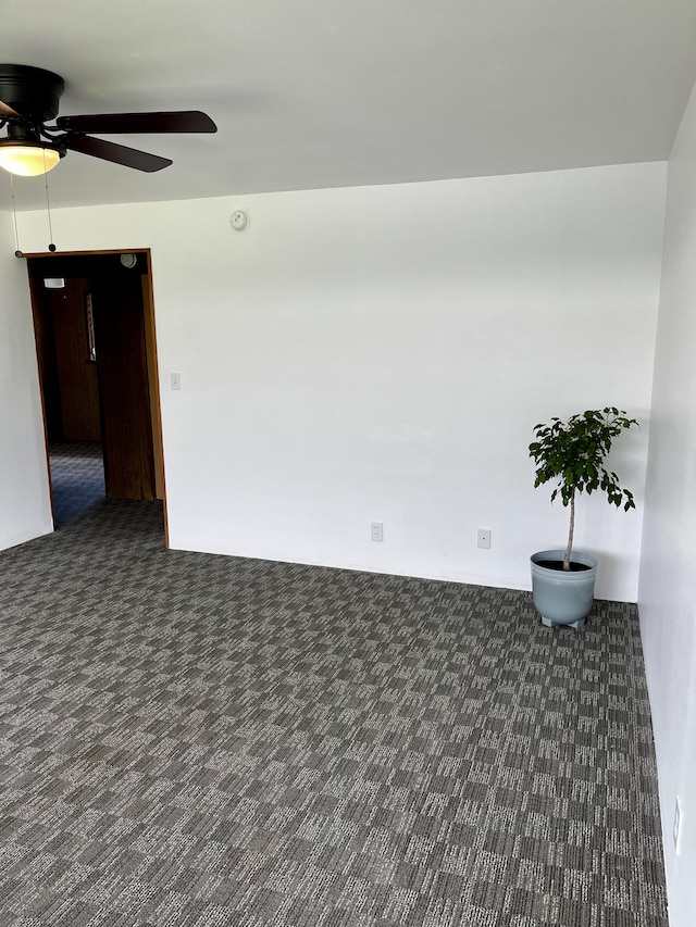 carpeted empty room with a ceiling fan