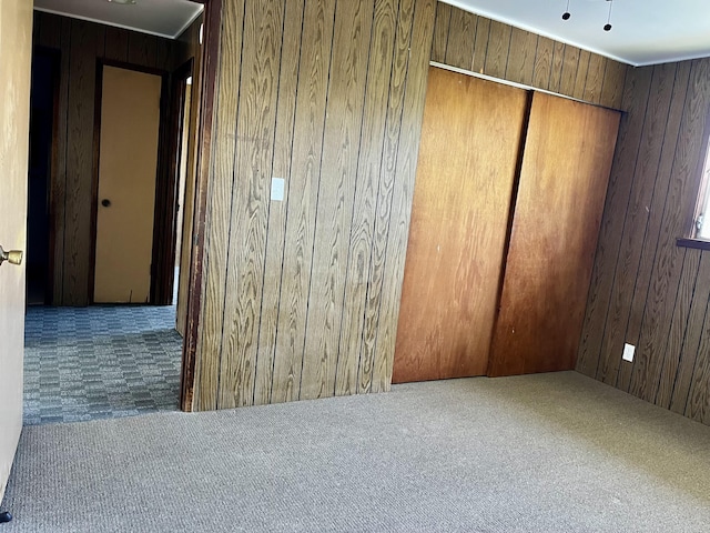 carpeted spare room with wooden walls