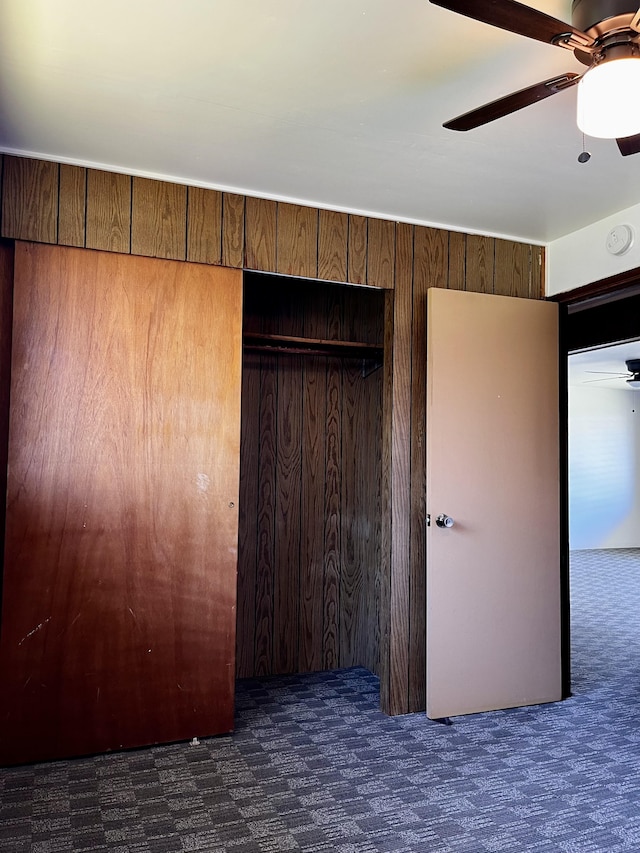 unfurnished bedroom featuring ceiling fan, a closet, and carpet flooring