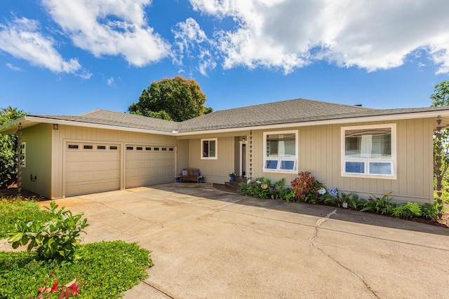 ranch-style house with a garage, driveway, and a shingled roof