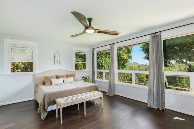 bedroom featuring dark wood-style flooring, multiple windows, a ceiling fan, and baseboards