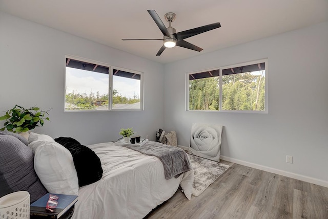 bedroom featuring a ceiling fan, baseboards, and wood finished floors