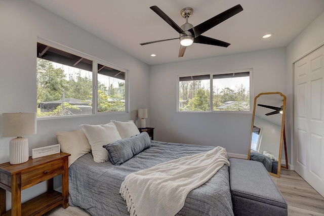 bedroom featuring light wood-type flooring, a ceiling fan, and recessed lighting