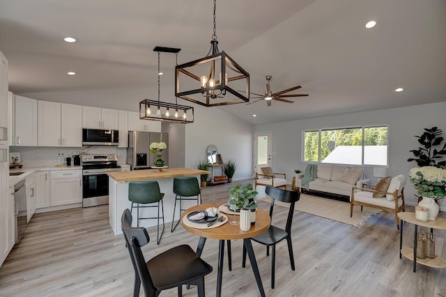 dining space featuring vaulted ceiling, light wood finished floors, baseboards, and recessed lighting