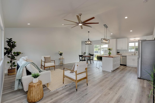 interior space with light wood-style floors, lofted ceiling, a ceiling fan, and recessed lighting