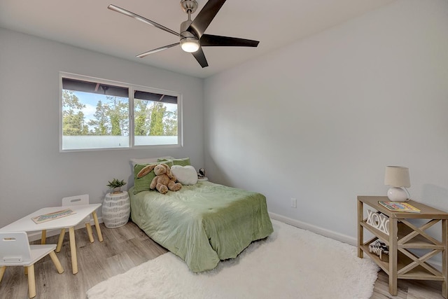 bedroom featuring ceiling fan, baseboards, and wood finished floors