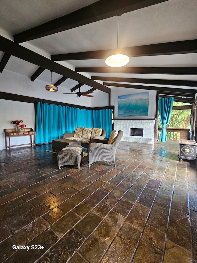 living room with a ceiling fan, brick floor, a fireplace, and lofted ceiling with beams