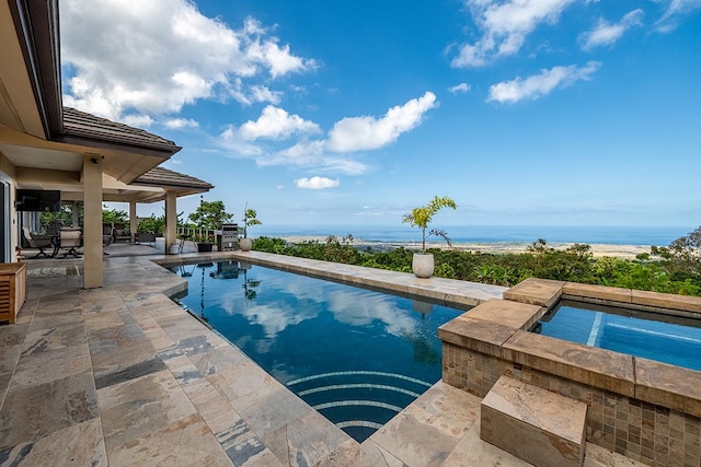 outdoor pool featuring an in ground hot tub and a patio area