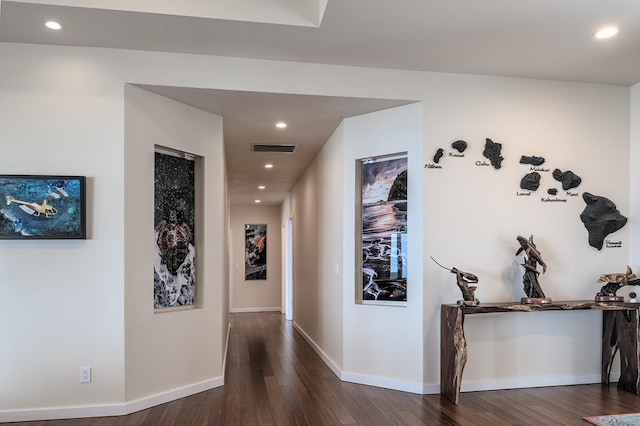 hallway with dark wood-style floors, visible vents, recessed lighting, and baseboards