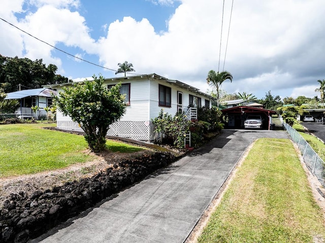 view of front of home with fence, a front lawn, and a carport