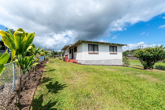 view of property exterior with fence and a yard