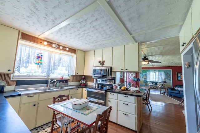 kitchen featuring stainless steel appliances, stainless steel counters, plenty of natural light, and a sink