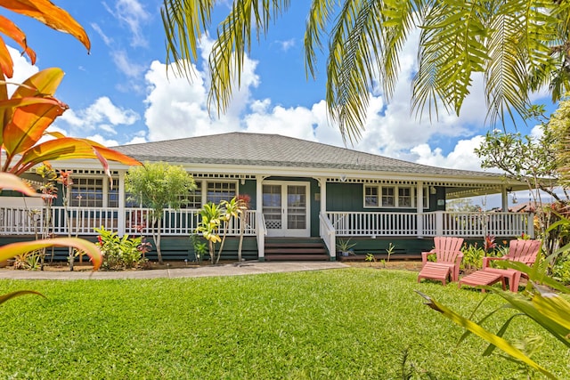 view of front of house featuring covered porch, roof with shingles, and a front lawn