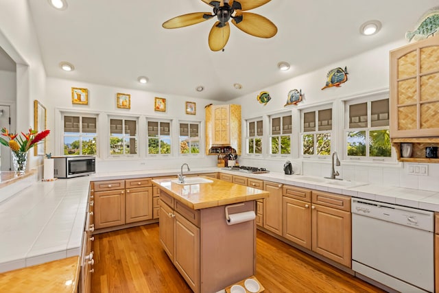 kitchen with tile counters, stainless steel appliances, and a sink