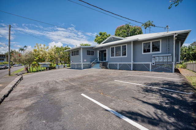 ranch-style house featuring metal roof and uncovered parking