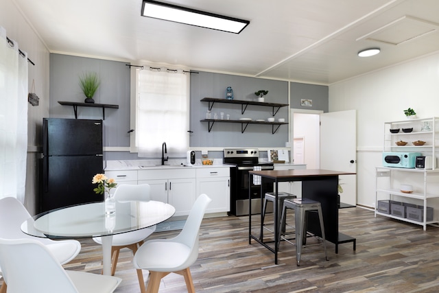 kitchen with electric stove, open shelves, dark wood-type flooring, freestanding refrigerator, and a sink