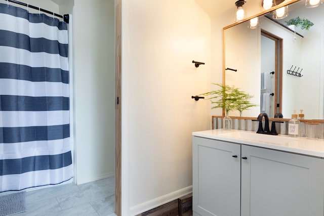 bathroom featuring a shower with curtain, vanity, and baseboards