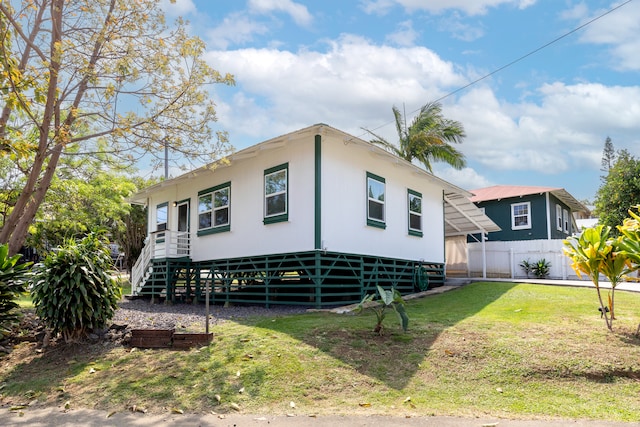 view of front of home with stairway, a front yard, and fence