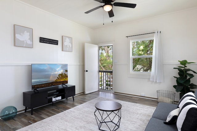 living room featuring a ceiling fan, crown molding, and wood finished floors