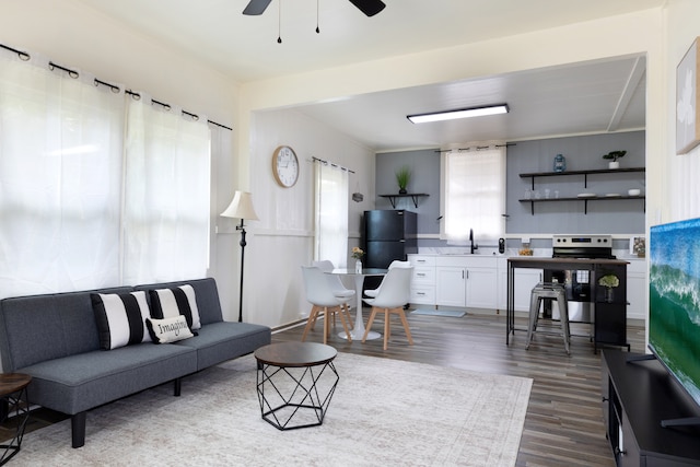 living area with a ceiling fan and dark wood-style flooring