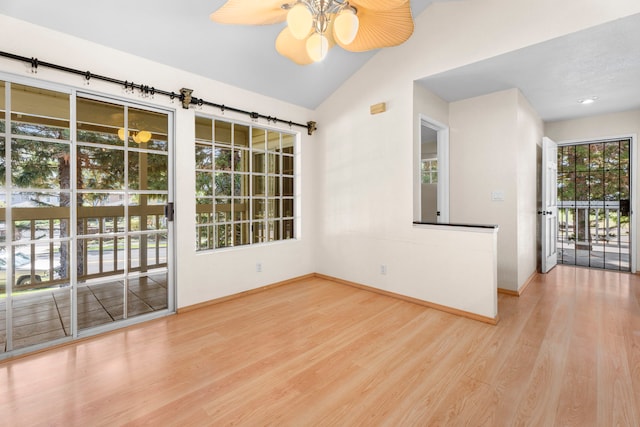 empty room with a ceiling fan, baseboards, vaulted ceiling, and wood finished floors