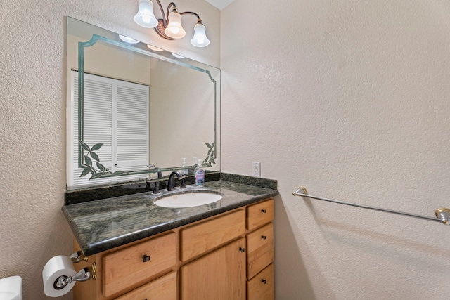 bathroom with a textured wall and vanity