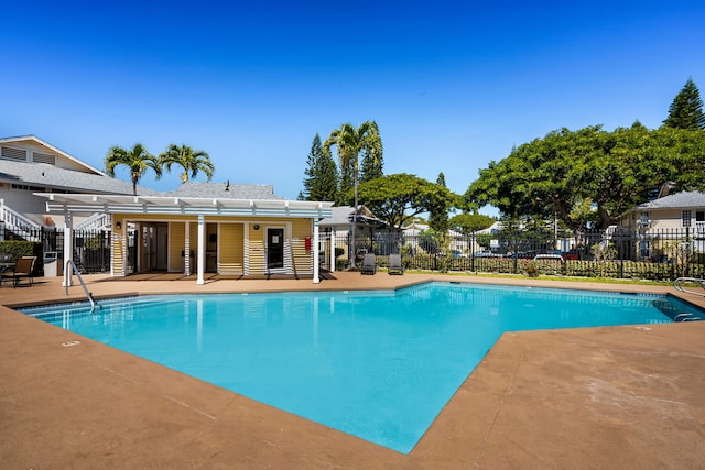 community pool with a patio and fence