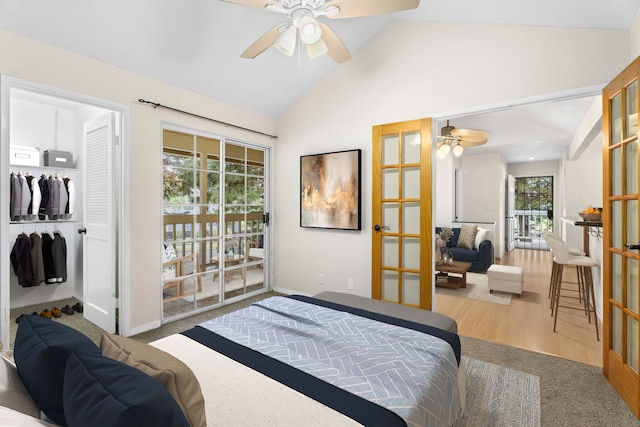 bedroom with vaulted ceiling, access to outside, french doors, and wood finished floors