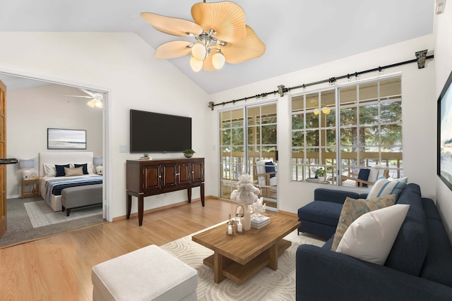 living room featuring vaulted ceiling, baseboards, a ceiling fan, and light wood-style floors