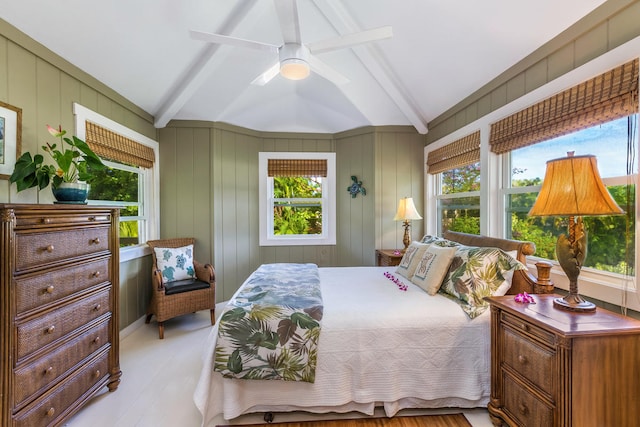 bedroom with ceiling fan, lofted ceiling with beams, and multiple windows