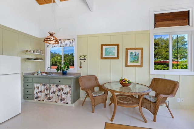 dining space with a towering ceiling and a decorative wall