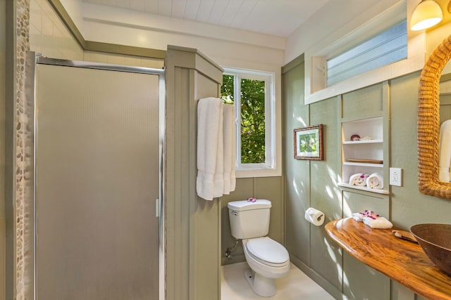 bathroom with a stall shower, a sink, and toilet