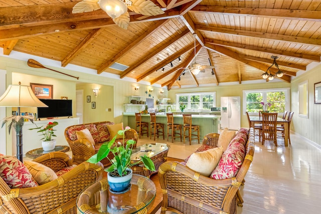 living area featuring vaulted ceiling with beams, ceiling fan, wooden ceiling, and wood finished floors