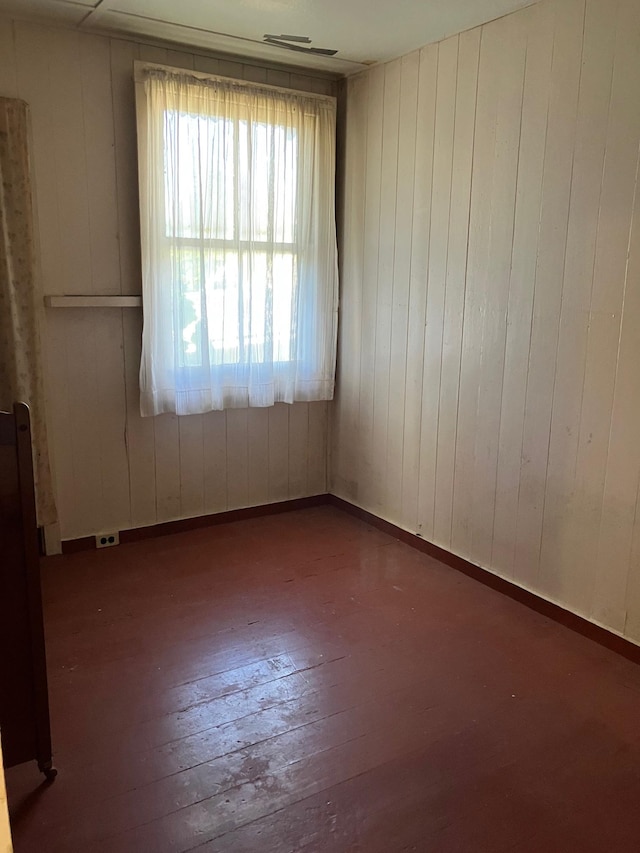 empty room featuring baseboards and wood-type flooring