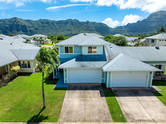 view of front of home featuring driveway, roof with shingles, and a front yard