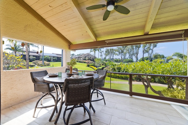 sunroom featuring vaulted ceiling with beams, wood ceiling, and ceiling fan