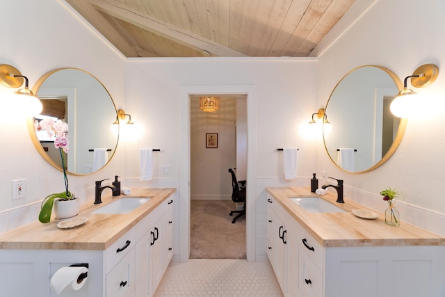 bathroom featuring wood ceiling, two vanities, and a sink