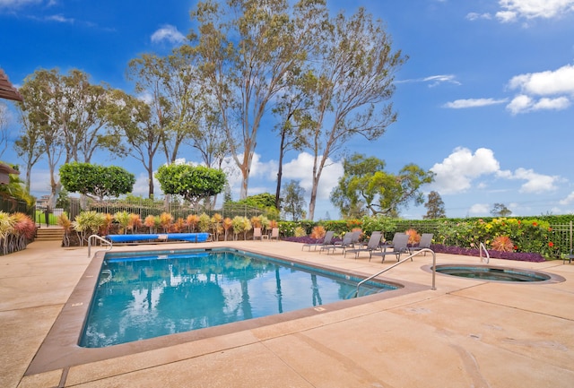 pool featuring fence, a community hot tub, and a patio