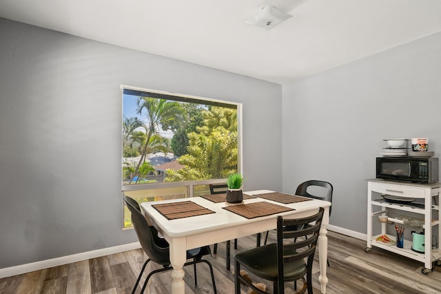 dining space with wood finished floors and baseboards