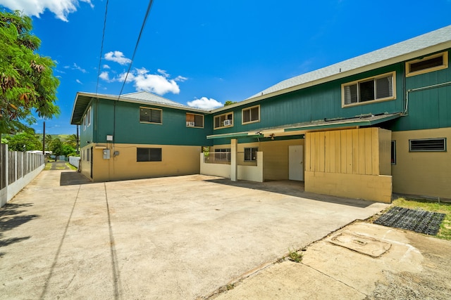 rear view of house with a patio area and fence